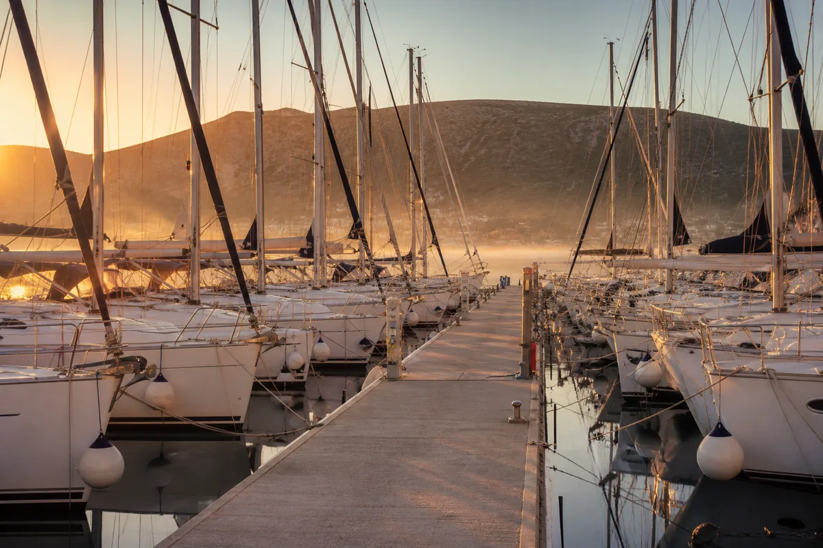 Voiliers de charter alignés le long des pontons d&rsquo;une marina dalmate au petit matin